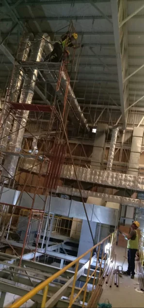 Scaffolding terpasang di dalam bangunan dengan pekerja di ketinggian