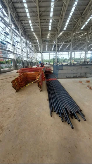 Pipa baja hitam dan frame scaffolding di bangunan beratap rangka baja